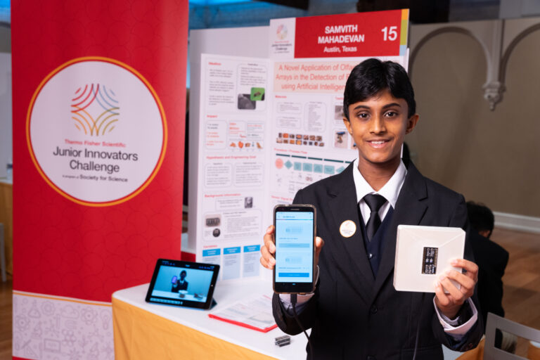 Mahadevan poses with The Allergent, a food allergy detection device.