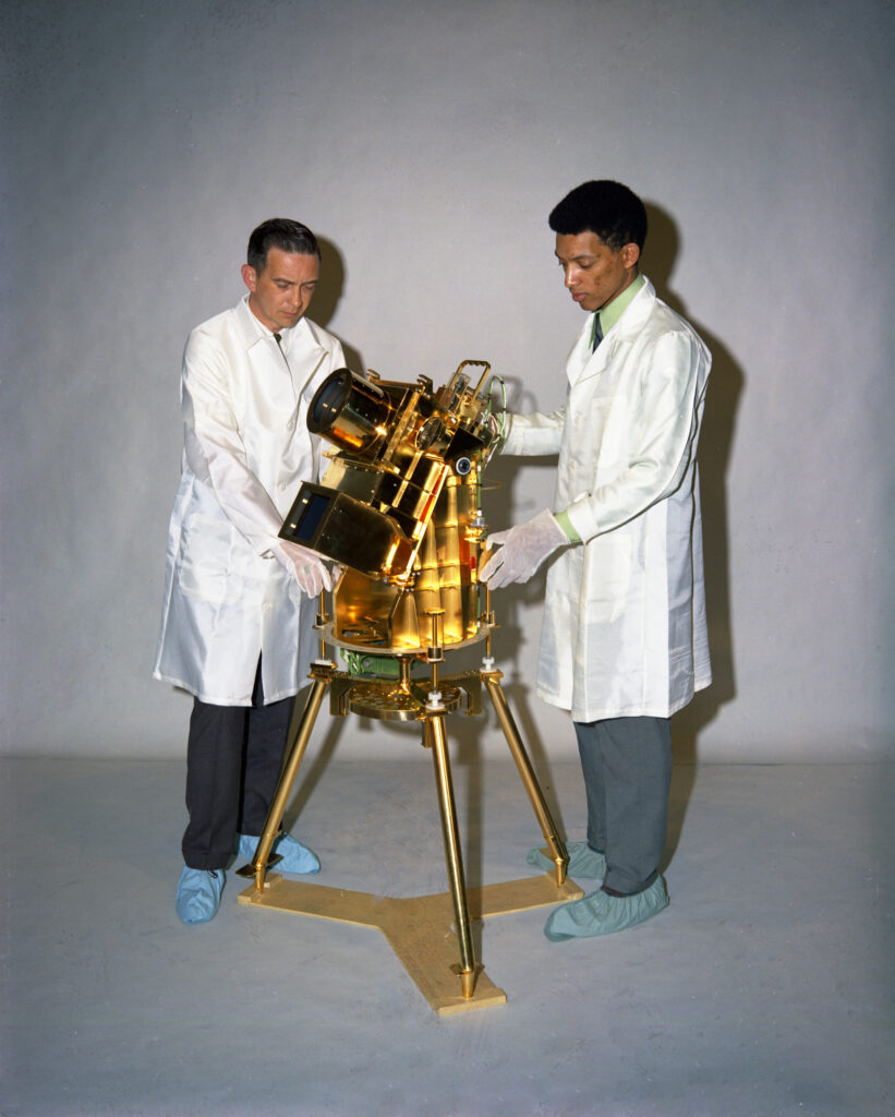 Dr. George Carruthers, and William Conway, project manager at the Naval Research Institute, examine the lunar surface far-ultraviolet camera/spectrograph.