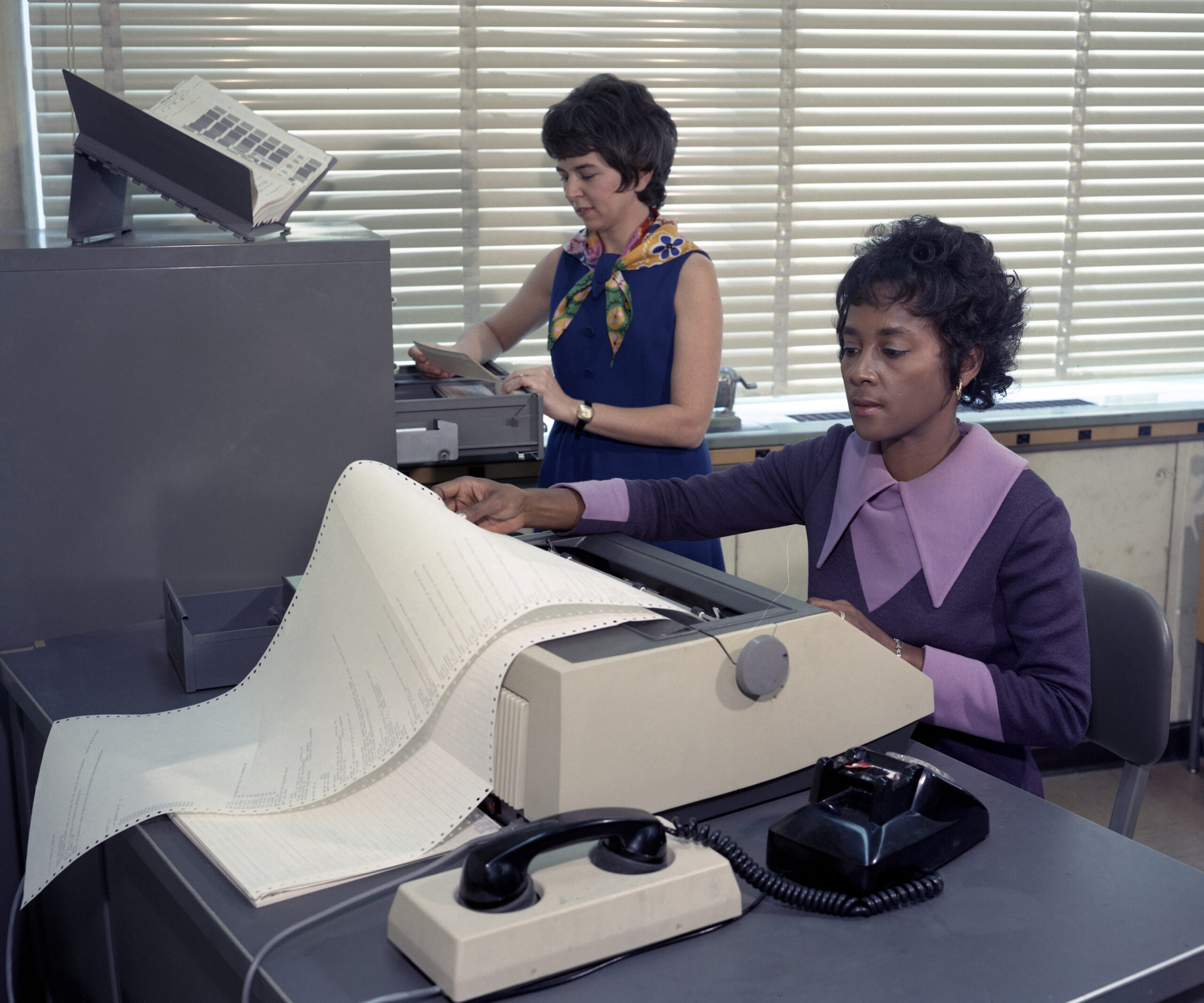 Annie Easley examines printouts from a machine.