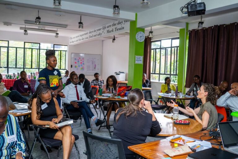 Maggie Flanagan offers candid feedback to a workshop of people in a classroom-like setting.