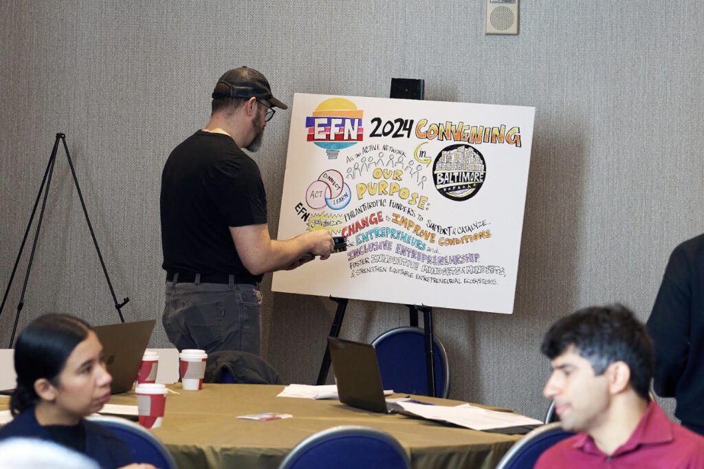 A man looking at a poster describing EFN 2024 convening